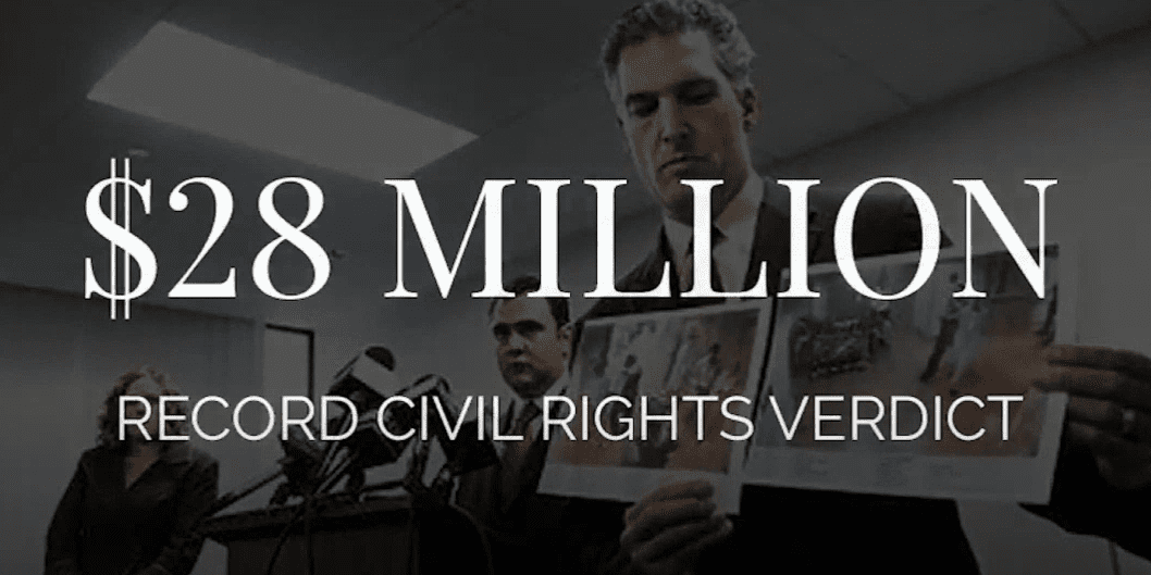 Attorney holding photos from a $28 million civil rights case verdict in Chicago.